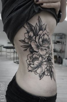 a woman's lower back tattoo with flowers on her stomach and the bottom half