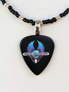 a black guitar pick with an eagle on it's face and the word grateful written in silver