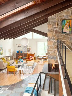 a living room filled with furniture and a fire place in the middle of an open floor plan