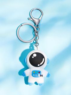 a keychain shaped like an astronaut with a smiley face on it's chest