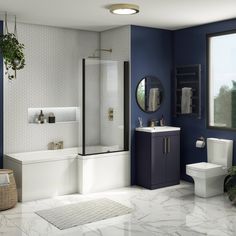 a modern bathroom with blue walls and white fixtures, including a toilet, sink, shower, and bathtub