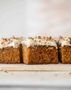 four pieces of carrot cake with white frosting