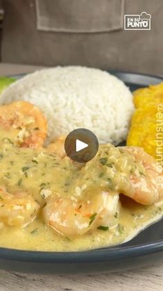 a plate with shrimp, rice and corn on the cob is shown in this video