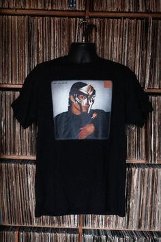 T-Shirt with iconic singer Sade holding a rose and wearing the mask of the legendary rapper DOOM. Hip Hop Halloween T-shirt For Streetwear, Fitted Pop Culture Fan Merchandise T-shirt, Fitted Pop Culture T-shirt For Fans, Fitted T-shirt For Fan Merchandise In Pop Culture Style, Fitted Pop Culture T-shirt For Streetwear, Fitted Black T-shirt With Pop Culture Style, Hip Hop T-shirt With Character Print For Fans, Madvillainy Album Cover, Album Cover Vintage