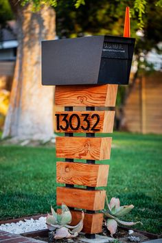 a mailbox sitting on top of a wooden post in the middle of a yard