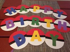 happy birthday sign made out of paper on a wooden table with red and white stripes