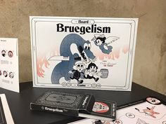 the board game bruegelism sits on a table next to its box and instructions