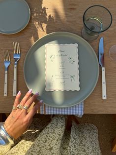 a person holding up a plate with a menu on it and silverware next to them