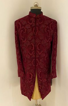 Look dapper in this maroon colour full sleeved mandarin collared velvet indo western sherwani in asymmetric pattern crafted with thread work embroidery.The readymade sherwani also comes with a gold colour dupion silk churidar. Colour options available. Customisation available. Big size available. Red Long Sleeve Sherwani For Formal Occasions, Elegant Red Bandhgala For Ceremonial Occasions, Red Elegant Bandhgala For Ceremonial Occasions, Red Long Sleeve Sherwani For Wedding, Formal Red Long Sleeve Sherwani, Red Formal Long-sleeve Sherwani, Red Long Sleeve Formal Sherwani, Red Naqshi Kurta For Wedding, Red Fitted Sherwani With Traditional Drape