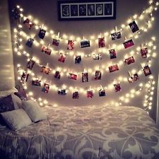 a bed with lights strung over it and pictures on the wall