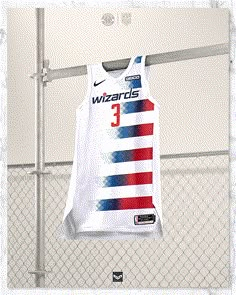 a basketball jersey hanging on a rack in front of a fence