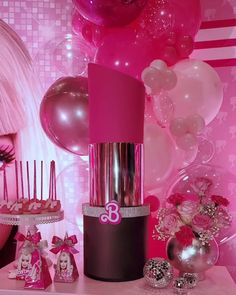 a display with pink lipstick and balloons in the background