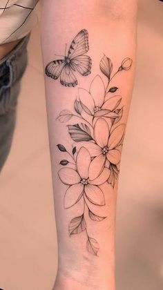 a woman's arm with flowers and a butterfly on the left side of her body