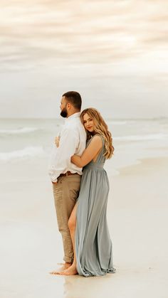 a man and woman embracing on the beach