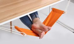 a person is sitting in a hammock with their feet propped up on the table