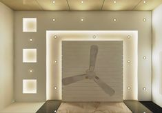 an empty room with a fan in the middle and lights on the wall behind it