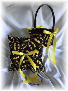 two black and yellow bags with batman symbols on them, tied to each other's sides