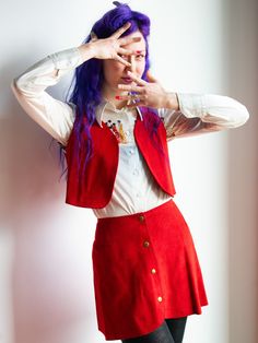 70's Bright Red Suede Snap Front Mini Skirt and Cropped Vest Two Piece Set A cutesy little number that can be worn together or separate, perfect for mod vibes or hippie vibes depending on how you style it. The red is bright and fun!! I also have a purple twin to this listed. The skirt snaps up the front with brass hardware and the vest is extra cropped to show off your waist and it is begging for a mega sleeve moment.  Nice condition, some variation in suede as is typical 11.5" Shoulders 32-34" Fitted Red Skirt With Buttons, Retro Red Skirt For Fall, Vintage Red Skirt For Party, Red Fitted Skirt With Buttons, Retro Red Skirt For Spring, Red Sleeveless Vest Crop Top, Vintage Red Party Skirt, 70s Vest And Skirt, Retro Red Fitted Vest