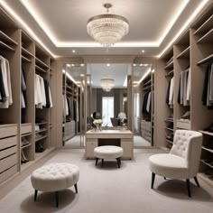 a walk in closet with two chairs and a foot stool