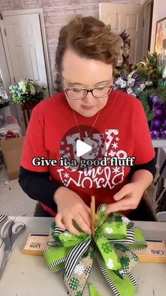 a woman is making a bow for her christmas tree ornament with green and white ribbons