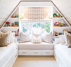 a room with two white couches and some bookshelves on the wall above them