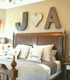 a bed room with a neatly made bed and two wooden letters on the wall above it