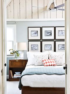 a bedroom with pictures on the wall above the bed