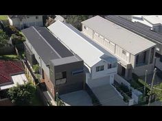 an aerial view of two houses with solar panels on the roof