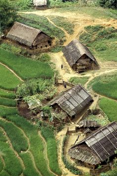 an aerial view of rice fields and huts in the countryside, with one person standing on top