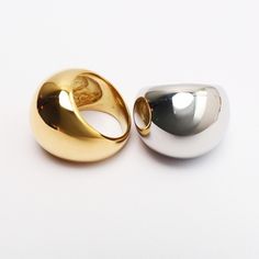 The Major Duomo Ring boasts a sleek dome shape, complete with a glossy finish and hollow center. Crafted from lightweight titanium steel and adorned with 18 karat yellow or white gold, this ring is both durable and elegant. Elegant Metal Dome Ring With Polished Finish, Elegant Polished Metal Dome Ring, Modern Wide Band Round Metal Ring, Modern Wide Band Metal Ring, Modern Wide Band Ring In Metal, Modern Metal Dome Ring With Polished Finish, Modern Open Dome Ring In Metal, Modern Metal Dome Open Ring, Modern Open Dome Ring