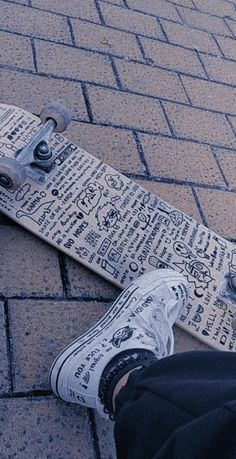 a person sitting on the ground with their feet propped up next to a skateboard