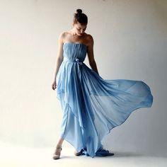 a woman in a blue dress poses for the camera