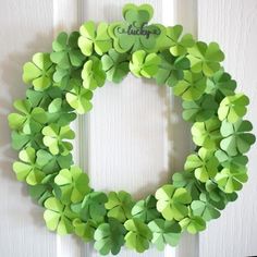 a wreath made out of green paper with shamrocks on the front and side of it