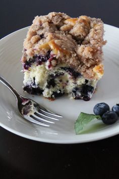 a piece of blueberry crumb cake on a plate with a fork