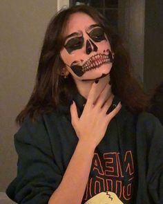 a woman with her face painted like a skeleton