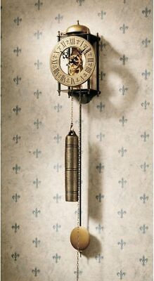 an old fashioned clock hanging from the side of a wall next to a cross pattern wallpaper