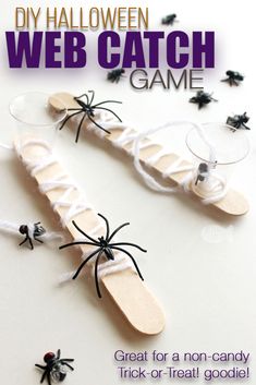 two wooden spoons decorated with black and white spider web garnishes for halloween