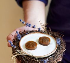 two small cookies sitting on top of a white plate in a bird's nest