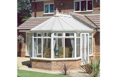 a house with a white sunroom and glass doors on the side of it's roof