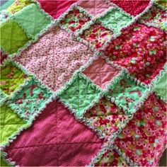 the quilt is made with many different colors and patterns, including pink, green, red, and white