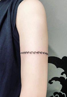 a woman's arm with a small arrow tattoo on the left side of her arm