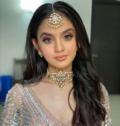 a woman with long hair wearing a necklace and earrings