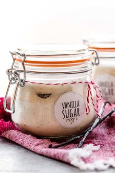 two jars filled with vanilla sugar sitting on top of a pink towel next to each other