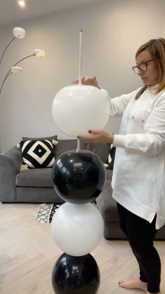 a woman standing next to a black and white balloon sculpture