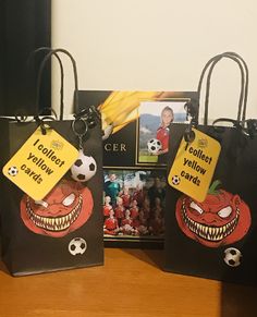 two bags with tags on them are sitting on a table next to an image of a soccer ball