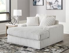 a white chair sitting on top of a rug in a living room