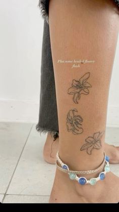 a woman's foot with tattoos on it and her ankle is covered in blue beads