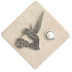 a bird is sitting on top of a tile with a button in it's center