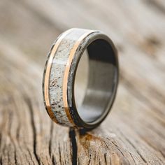 a wedding ring with antler wood and gold inlays on the outside of it