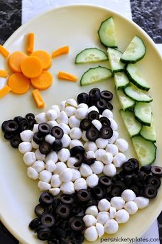 a plate with black olives, cucumber slices and carrots on it